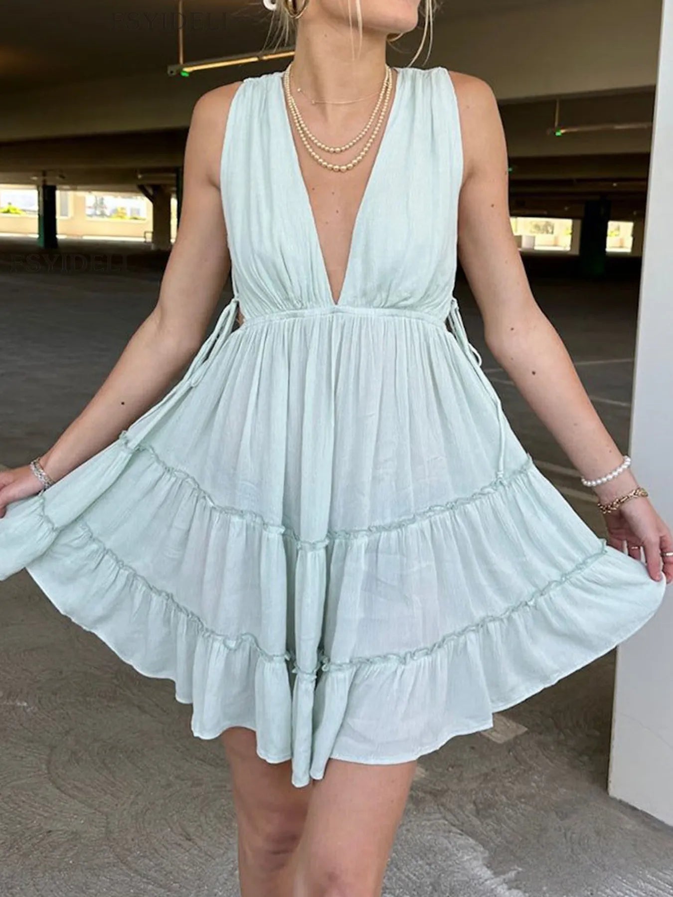 Deep V-Neck Tiered Mini Dress with Ruched, Lace-Up, and Frill Details.