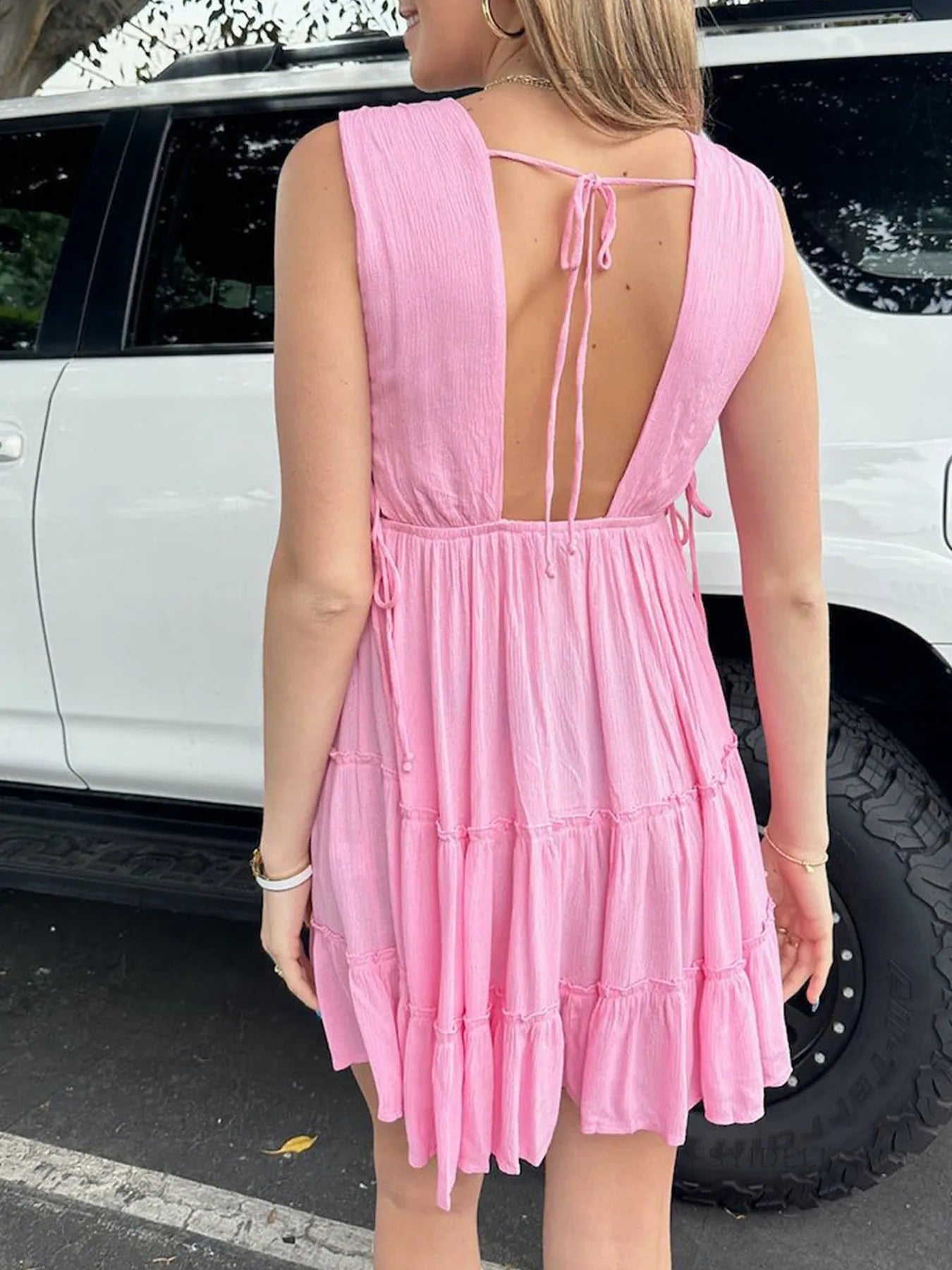 Deep V-Neck Tiered Mini Dress with Ruched, Lace-Up, and Frill Details.