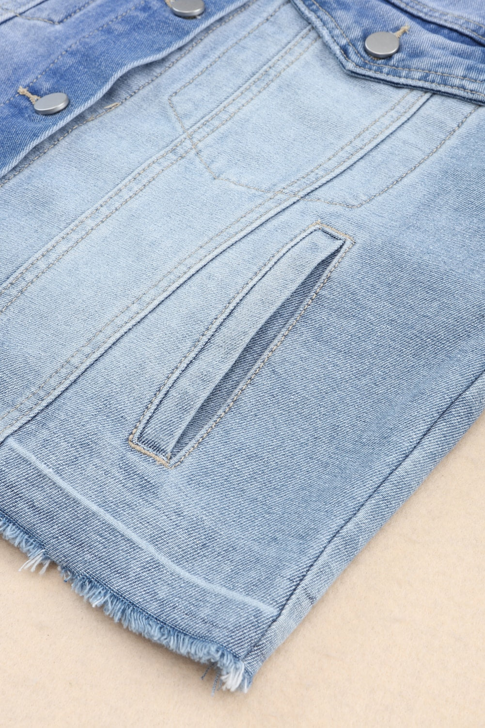 Distressed button up drop shoulder denim jacket with raw hem and pockets.