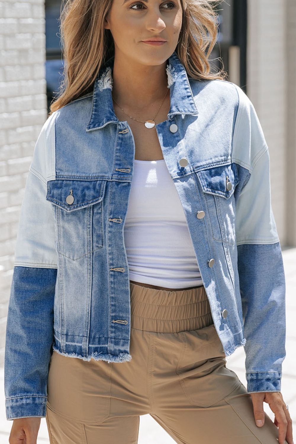 Distressed button up drop shoulder denim jacket with raw hem and pockets.
