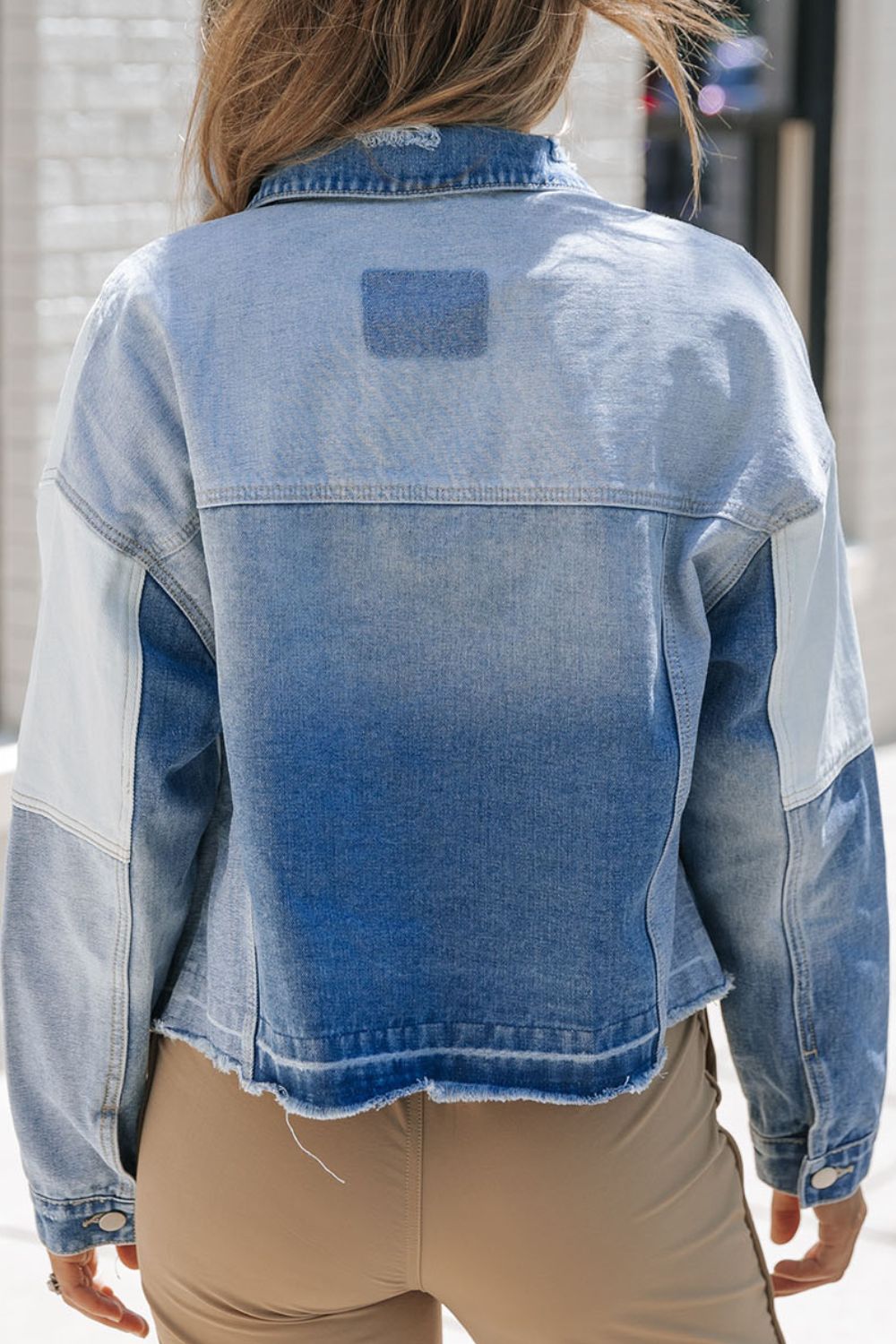 Distressed button up drop shoulder denim jacket with raw hem and pockets.
