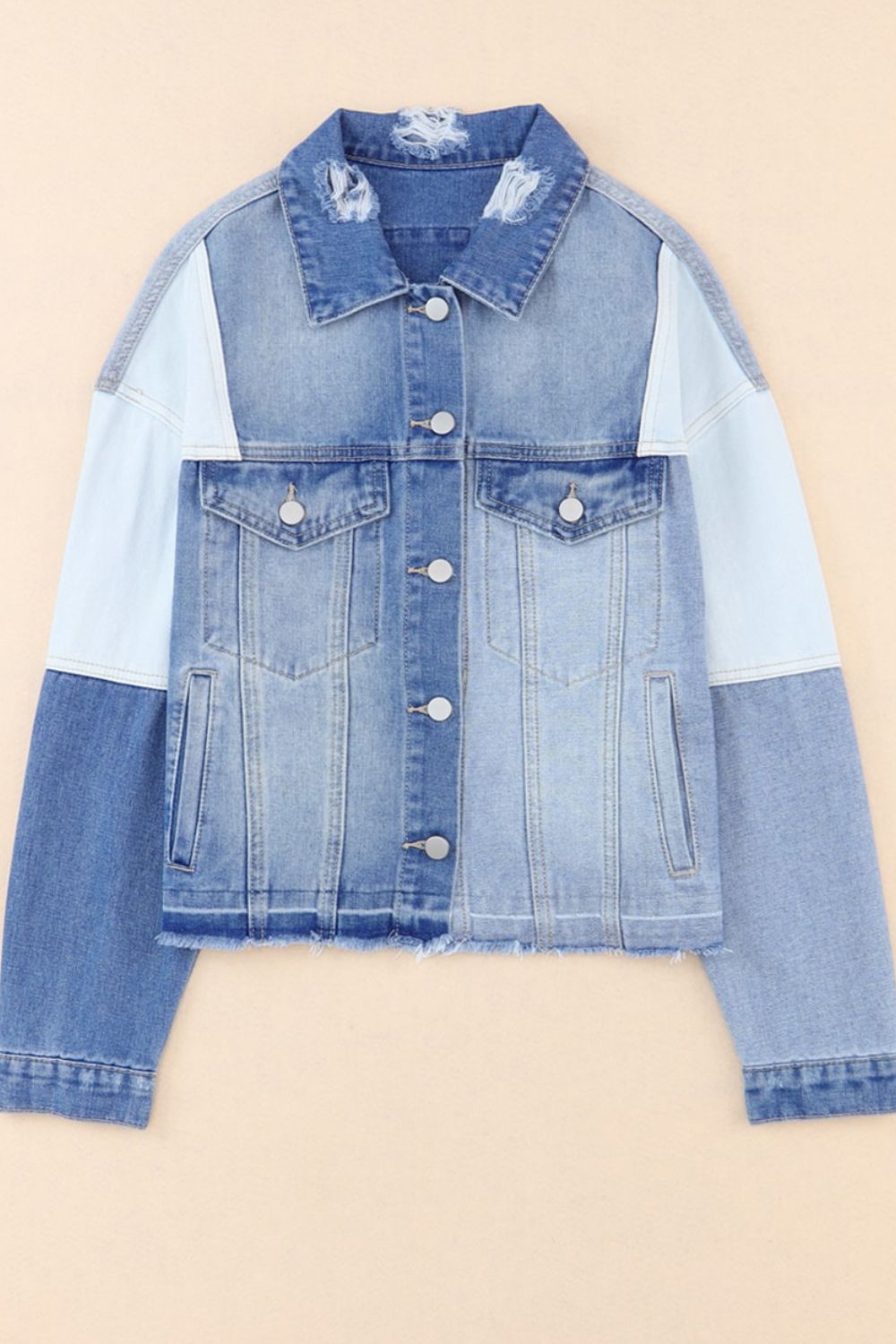 Distressed button up drop shoulder denim jacket with raw hem and pockets.