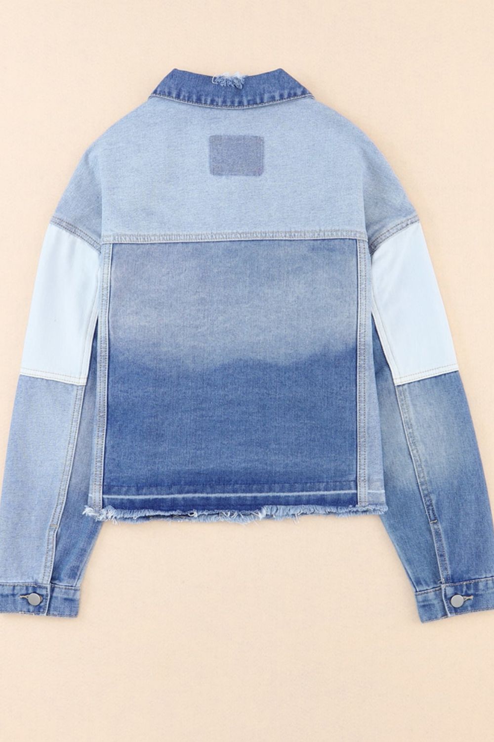 Distressed button up drop shoulder denim jacket with raw hem and pockets.