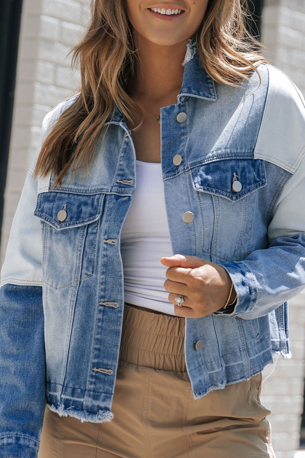 Distressed button up drop shoulder denim jacket with raw hem and pockets.