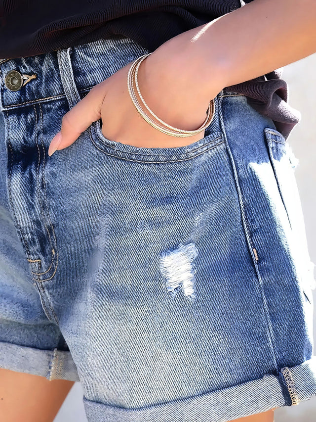 Women's distressed denim shorts with pockets and cat's whisker detail.