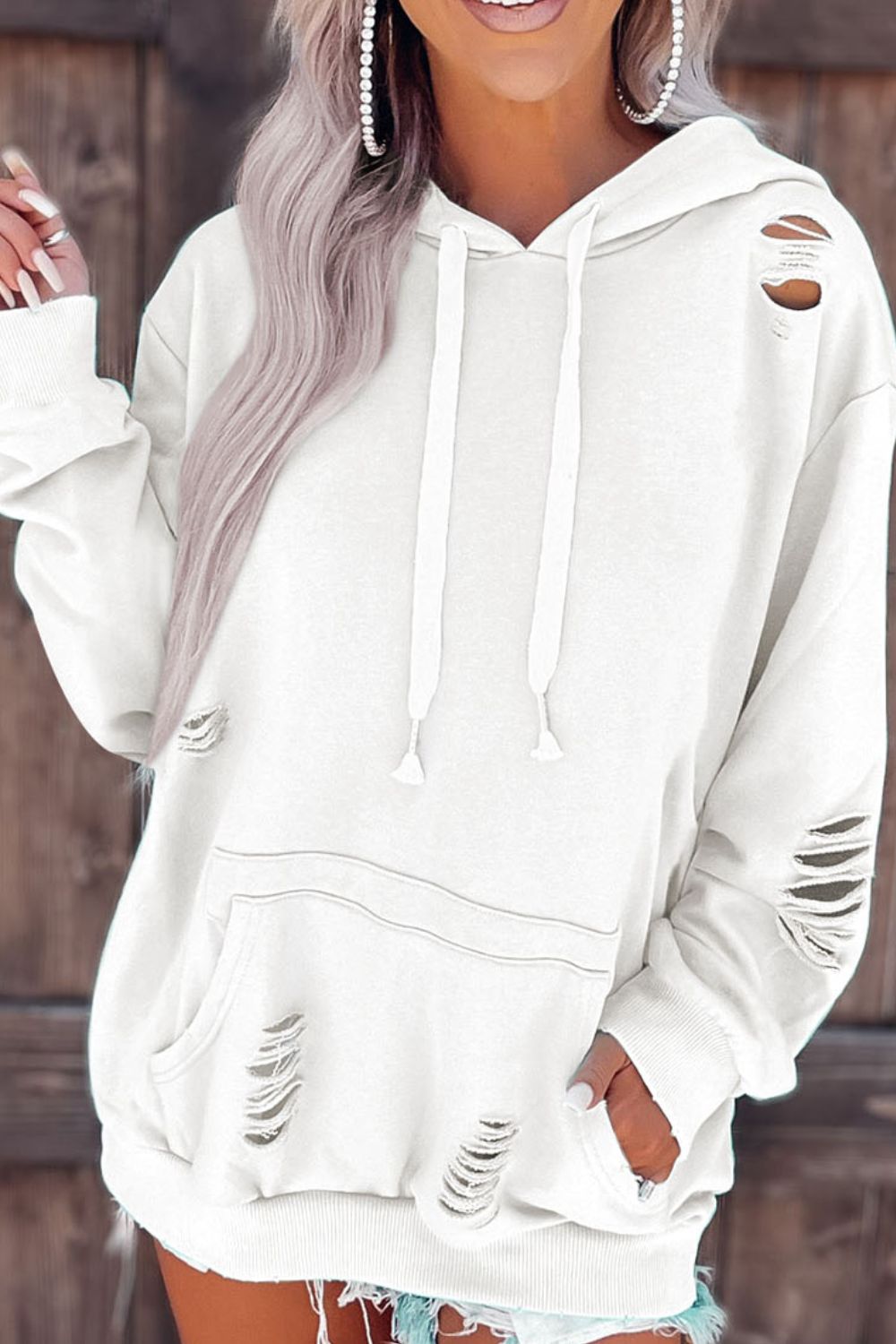 Distressed drawstring long sleeve hoodie with pockets.