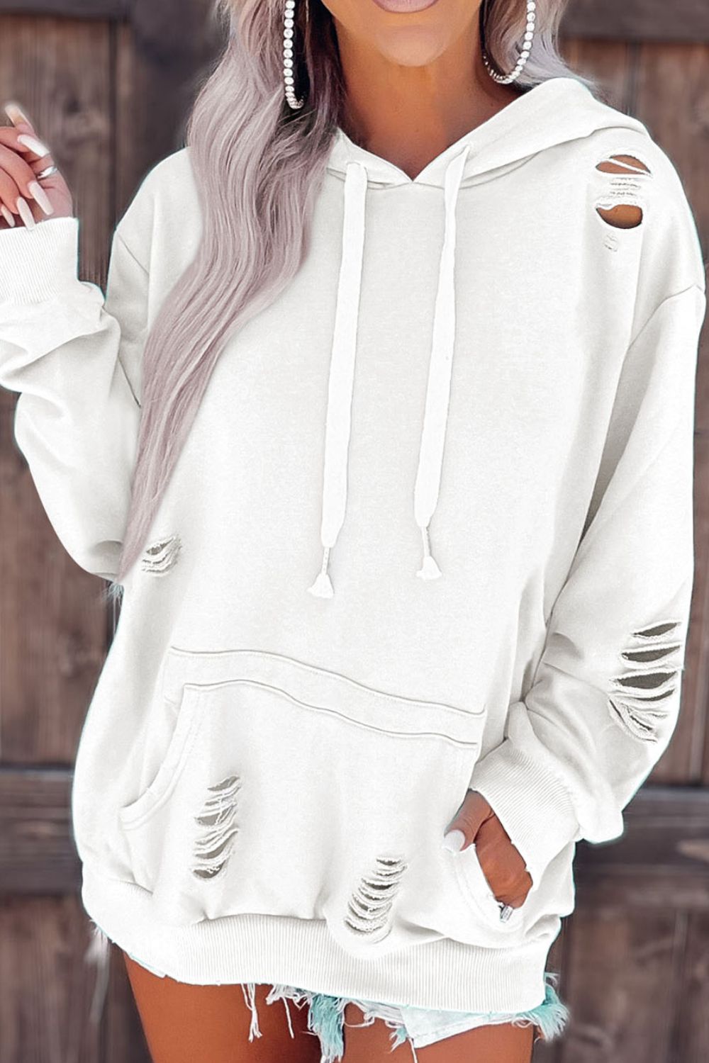Distressed drawstring long sleeve hoodie with pockets.
