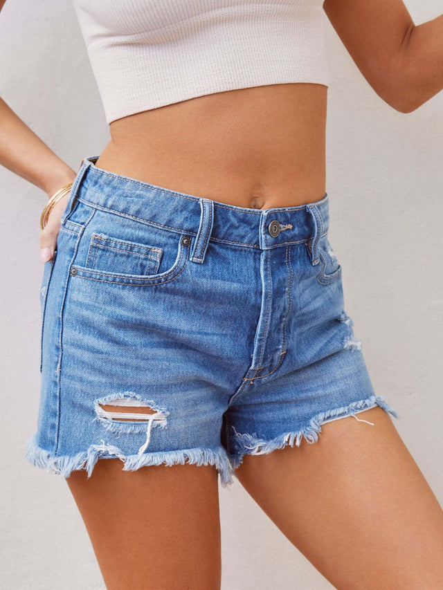Distressed raw hem denim shorts with pockets and buttons.