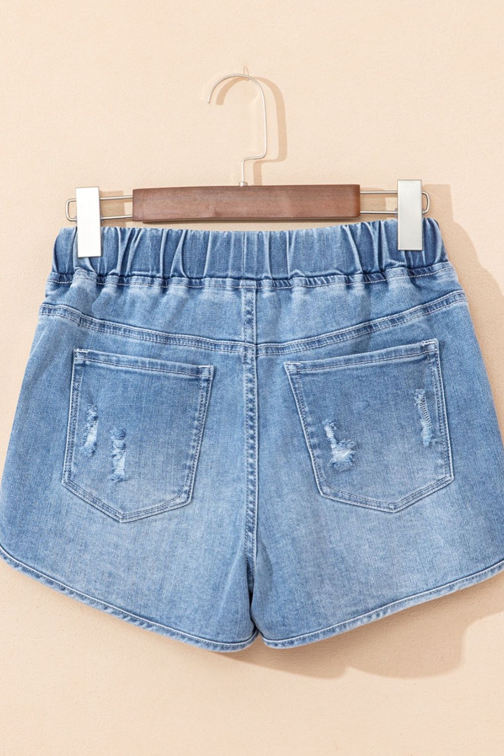 Drawstring high-waist distressed denim shorts with pockets.
