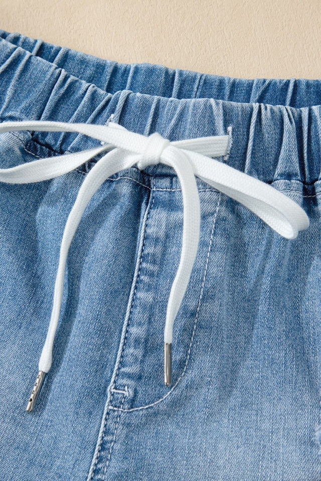 Drawstring high-waist distressed denim shorts with pockets.