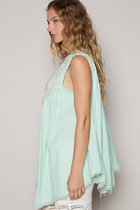 Embroidered pearls open front sleeveless cardigan with lace detail and raw hem.