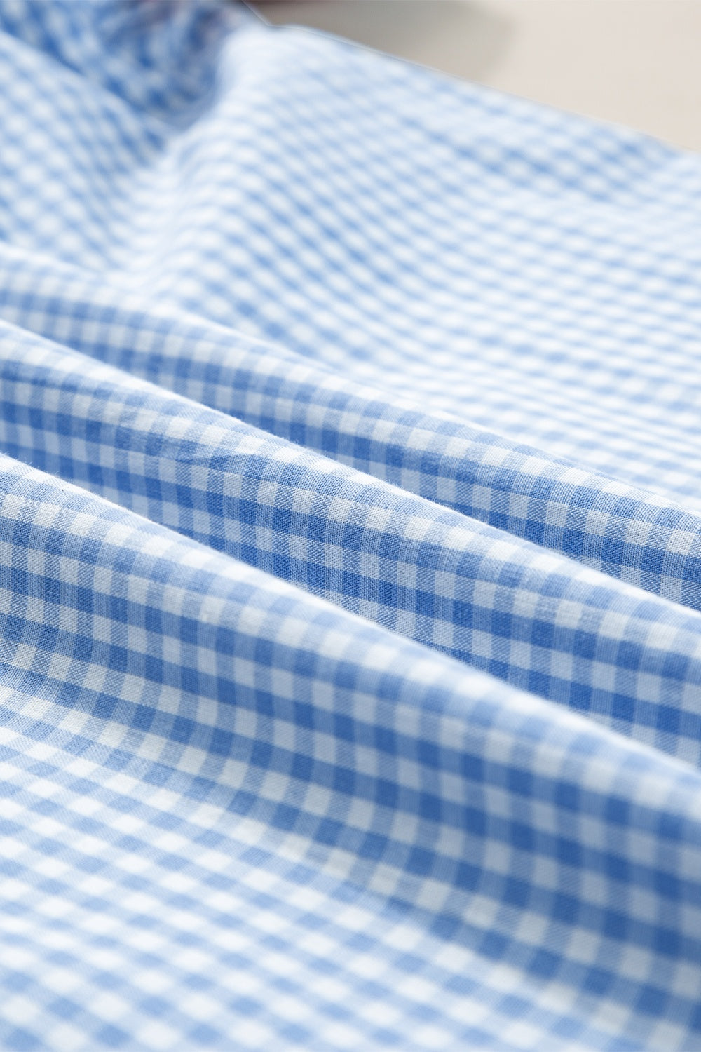 Embroidered plaid round neck short sleeve blouse.