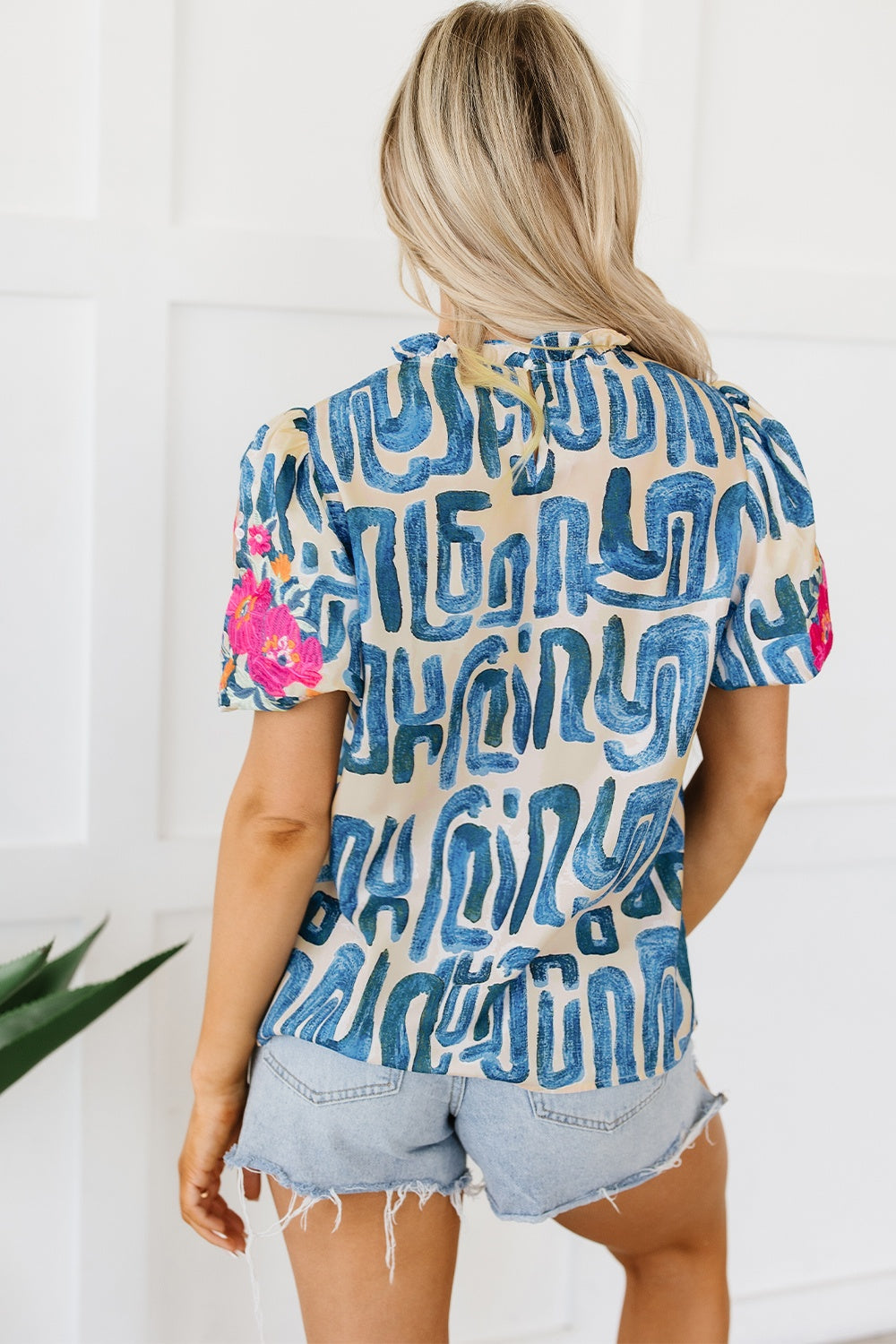 Embroidered printed mock neck short sleeve blouse.