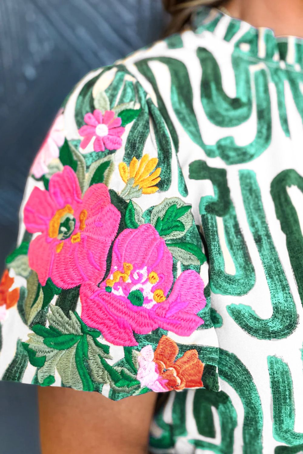 Embroidered printed mock neck short sleeve blouse.