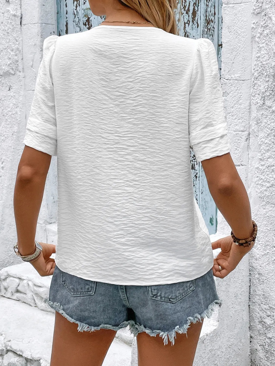 Embroidered V-neck short sleeve top with buttons.