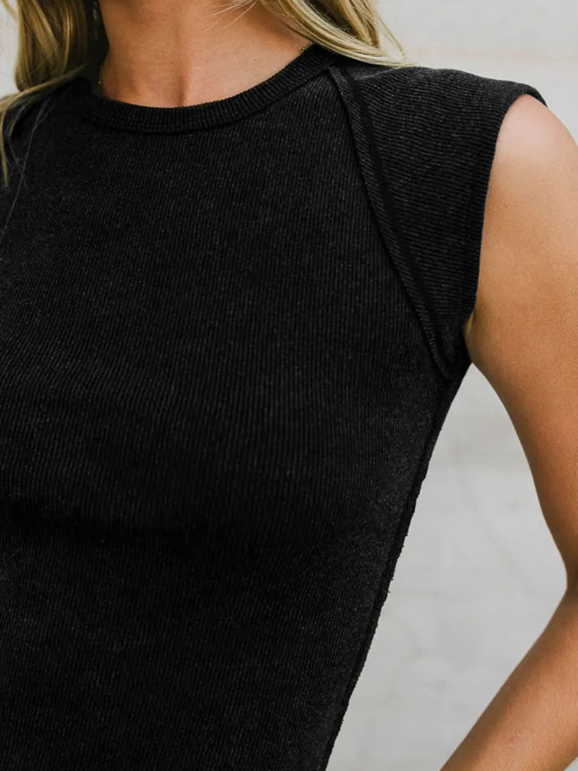 Round neck tank top with exposed seam details.