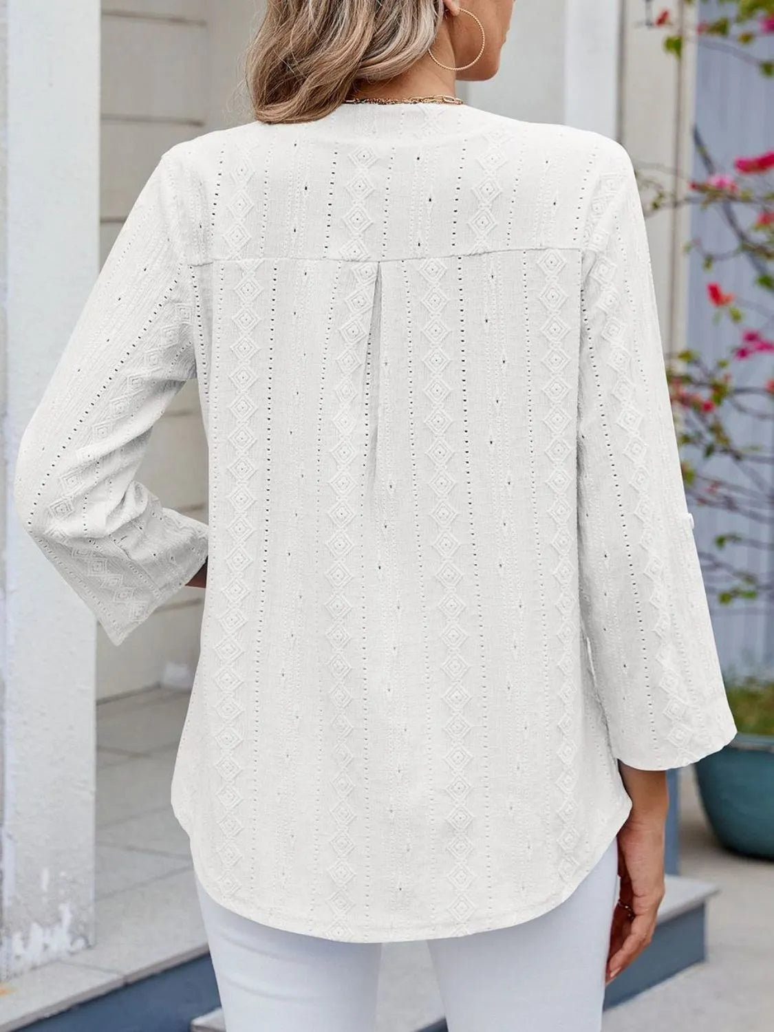 Eyelet notched roll-tab sleeve top.