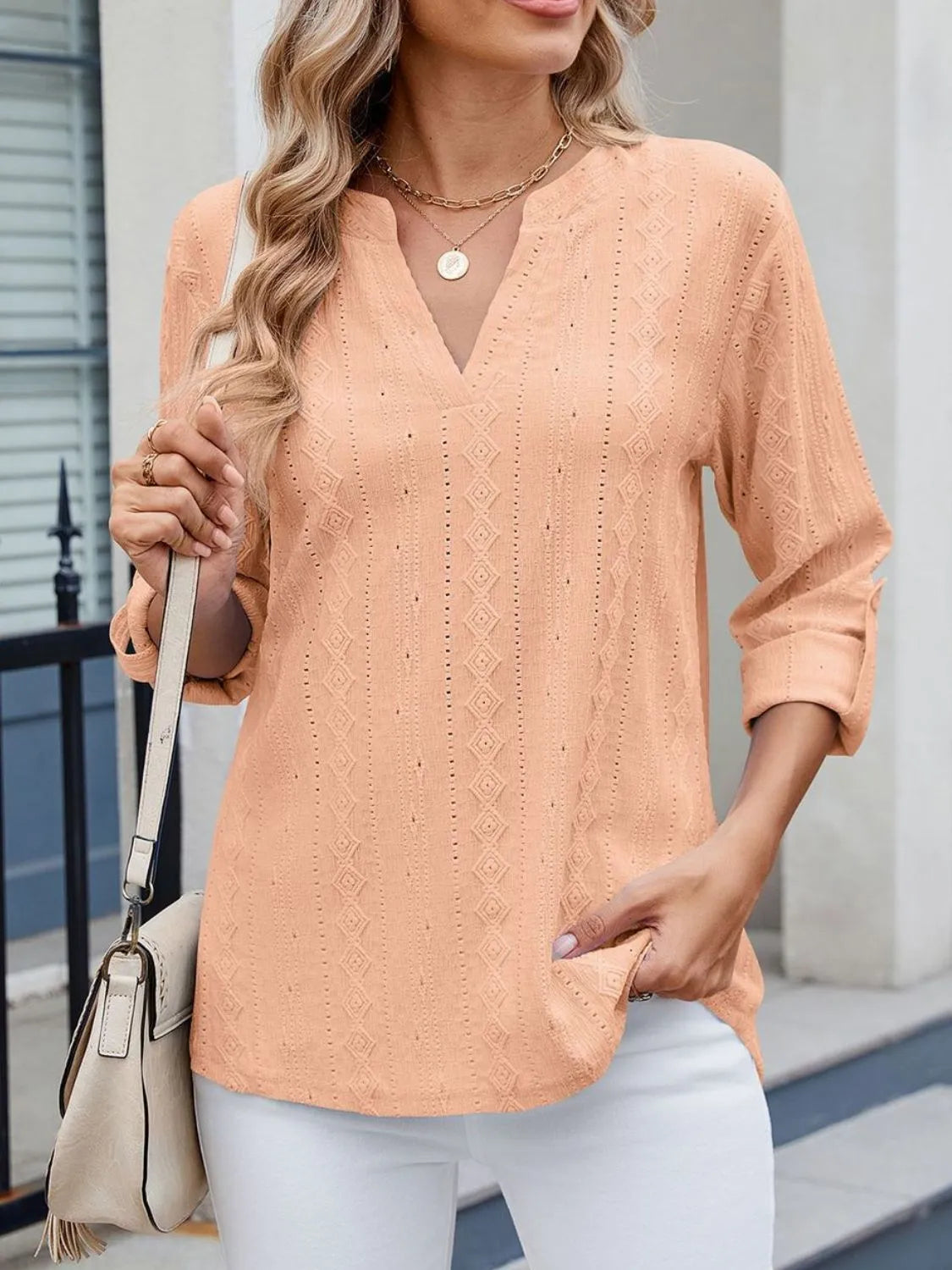 Eyelet notched roll-tab sleeve top.