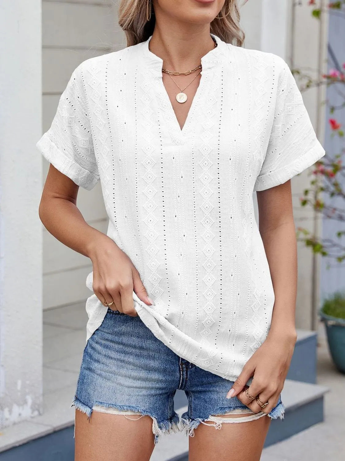 Eyelet notched short sleeve top.