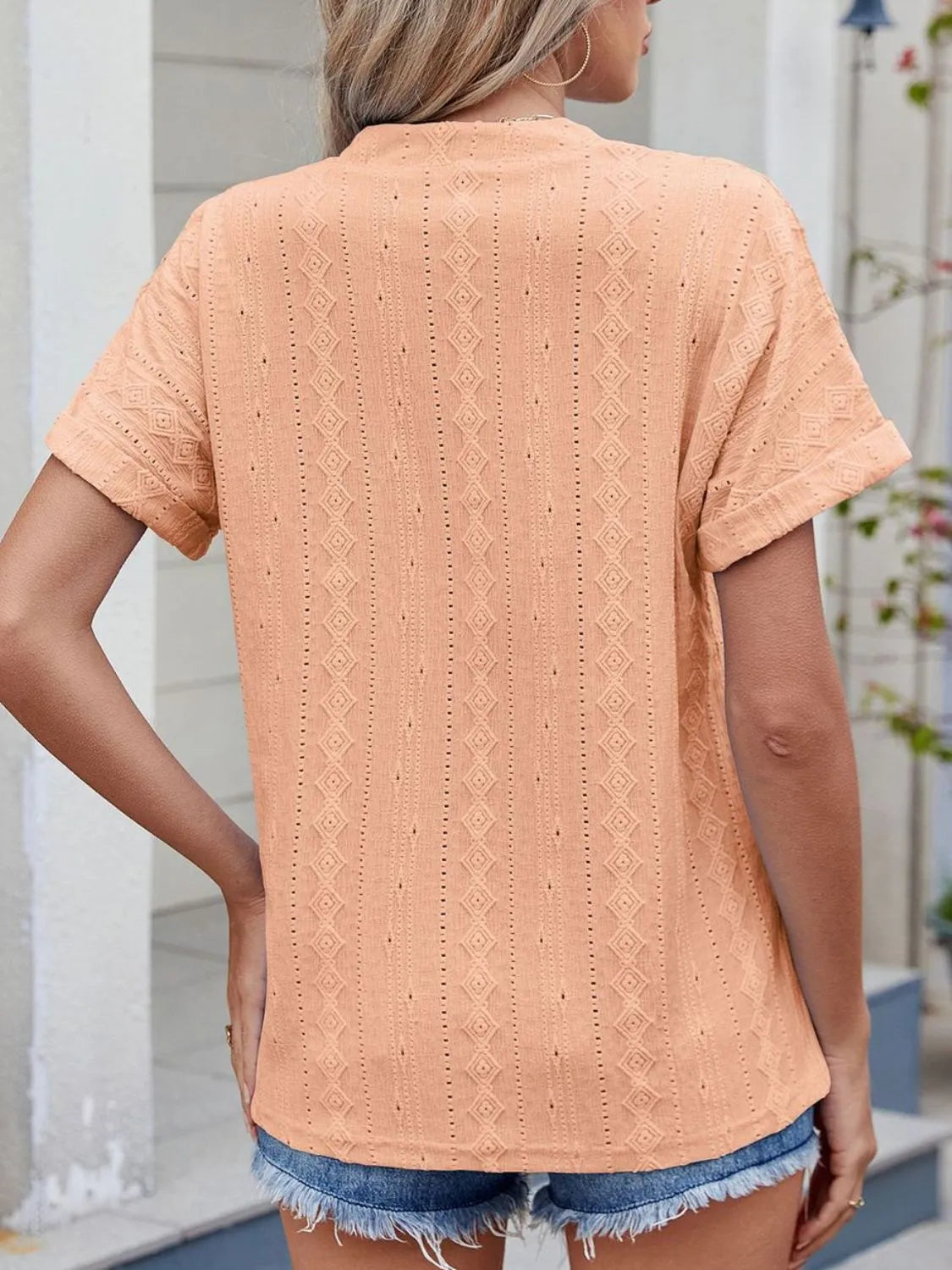 Eyelet notched short sleeve top.