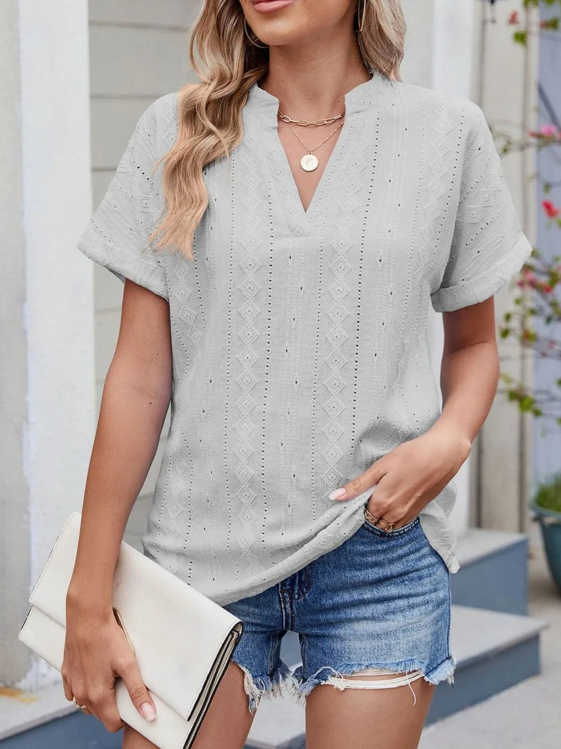 Eyelet notched short sleeve top.