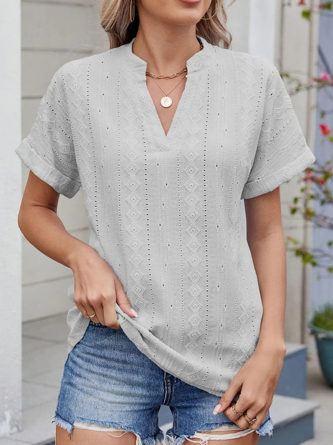 Eyelet notched short sleeve top.