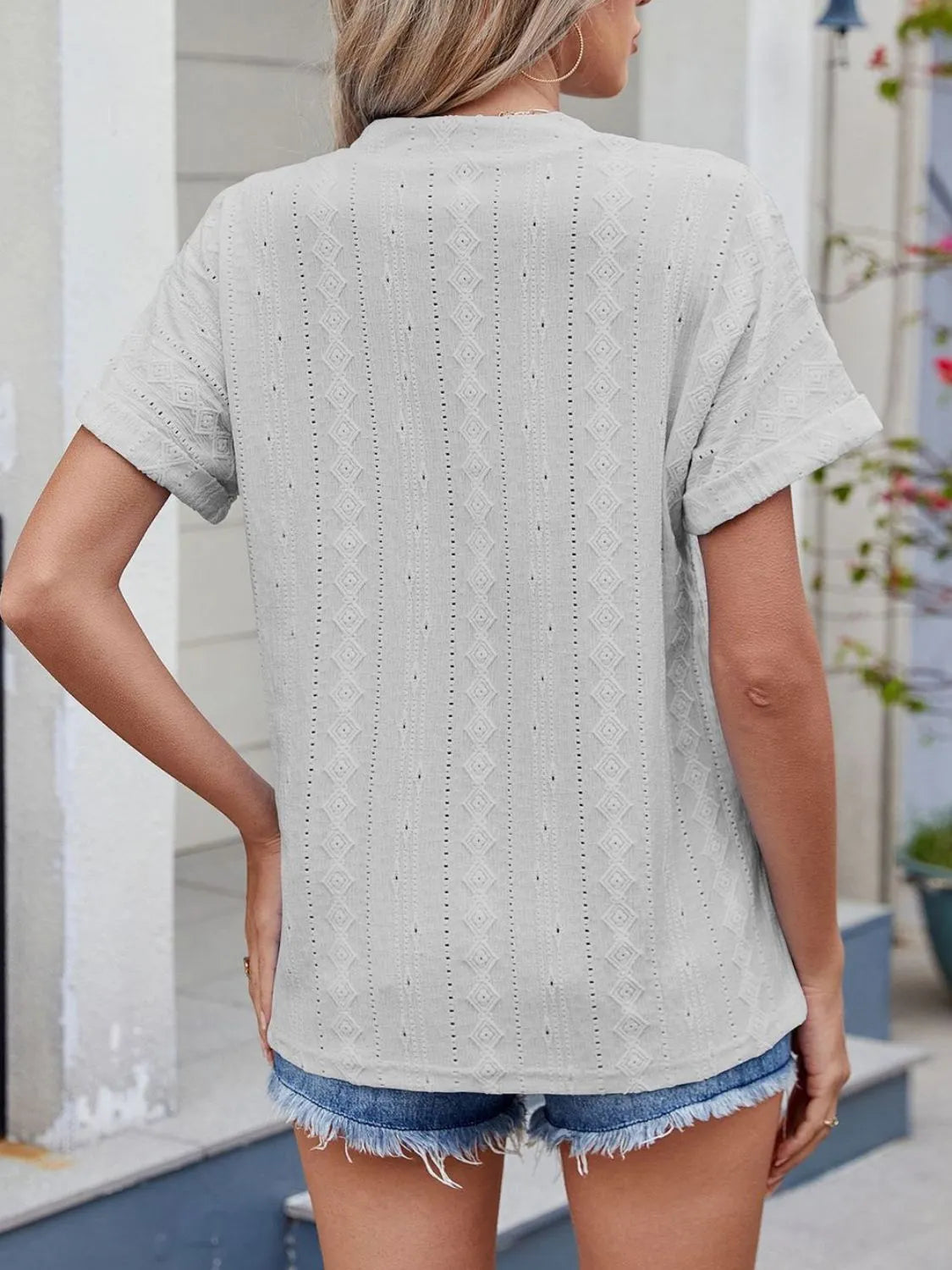 Eyelet notched short sleeve top.
