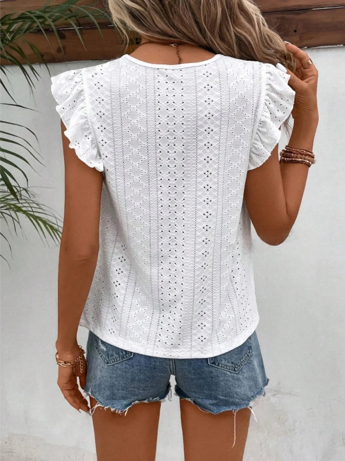 Eyelet round neck cap sleeve top with cutout.