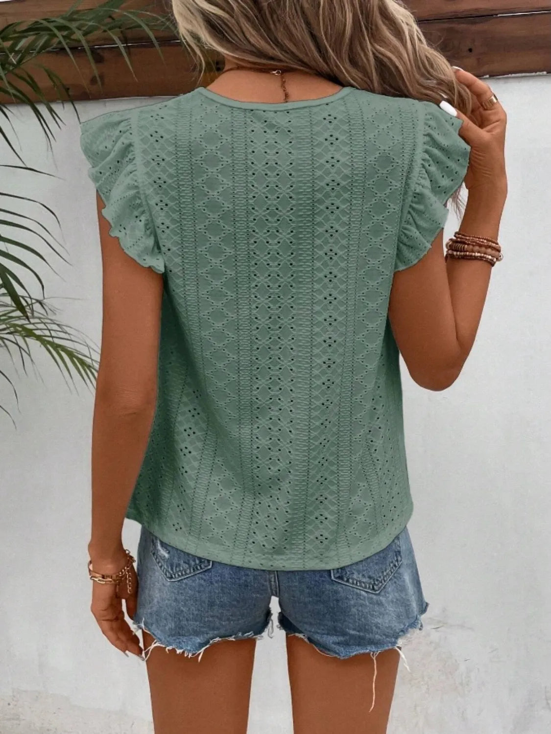 Eyelet round neck cap sleeve top with cutout.