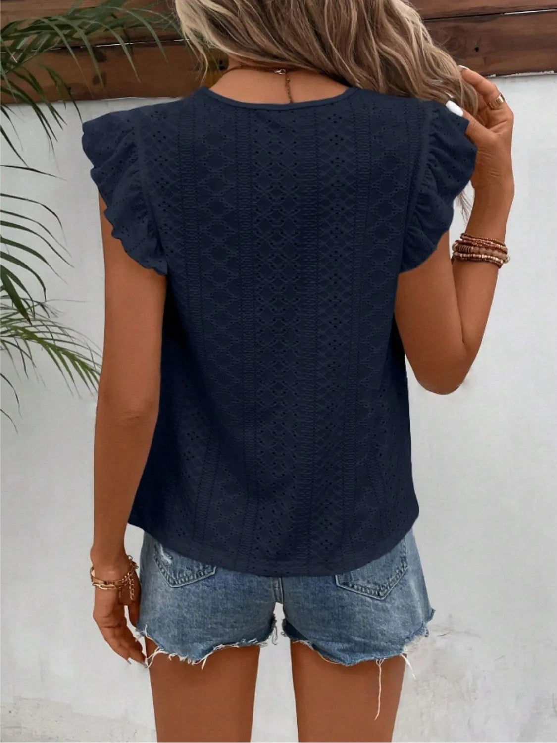 Eyelet round neck cap sleeve top with cutout.