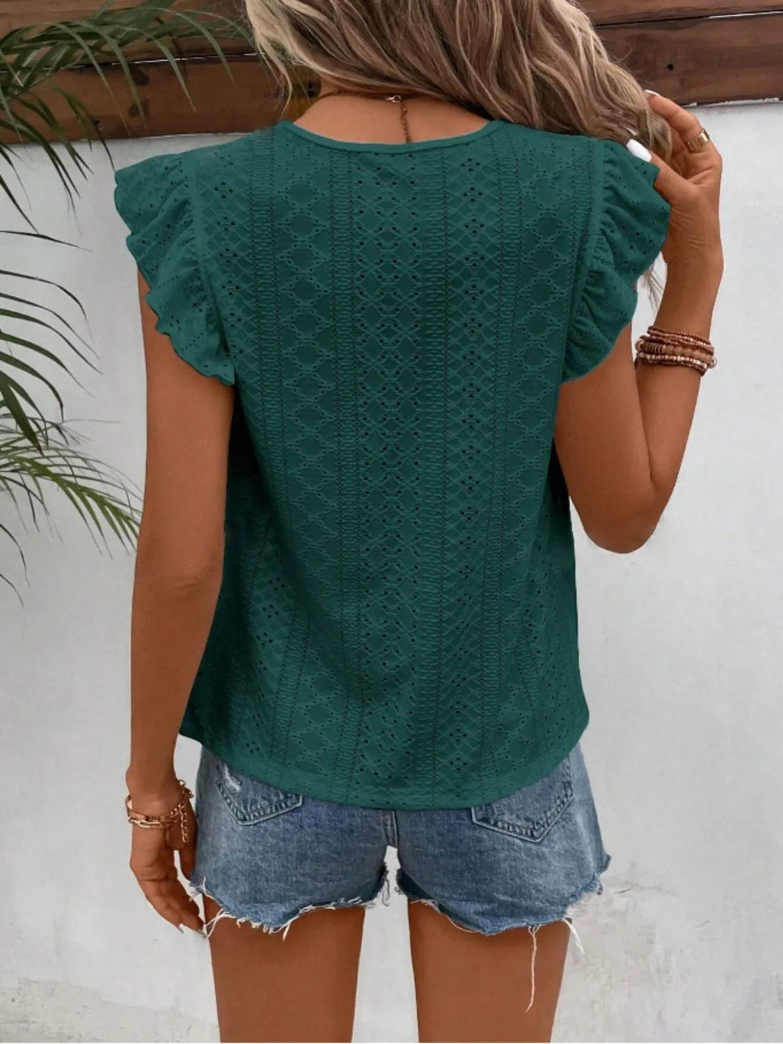 Eyelet round neck cap sleeve top with cutout.