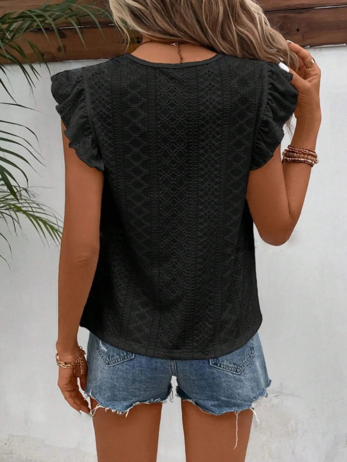 Eyelet round neck cap sleeve top with cutout.
