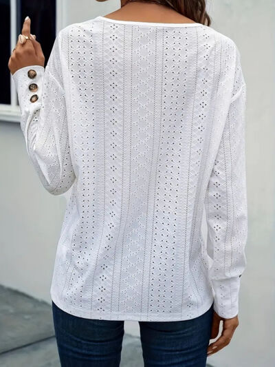 Eyelet V-neck long sleeve blouse with cutout and decorative buttons.