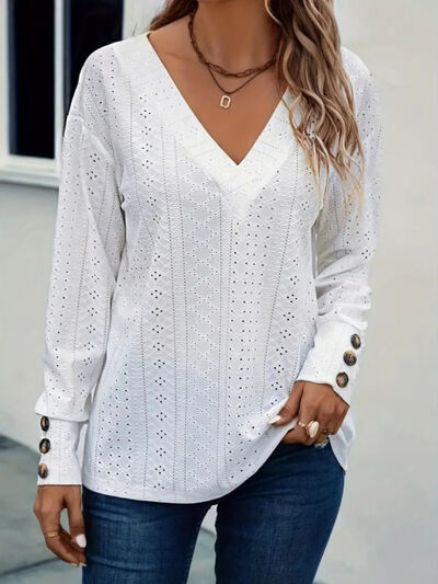 Eyelet V-neck long sleeve blouse with cutout and decorative buttons.