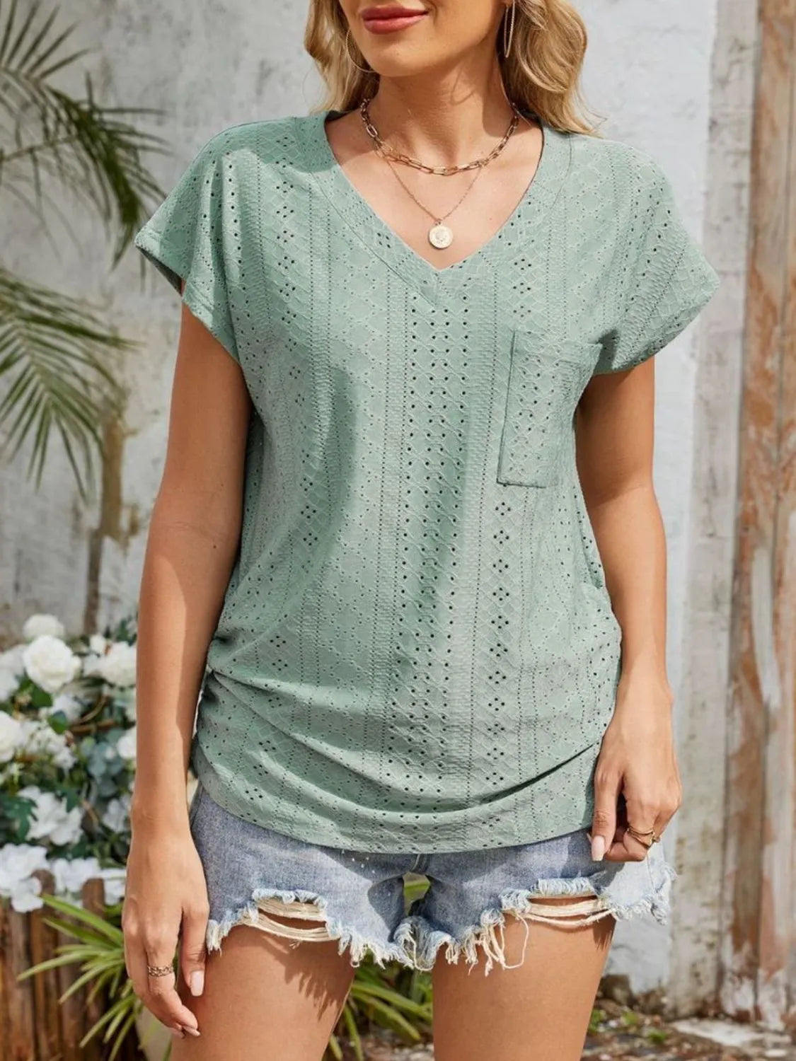 Eyelet V-neck short sleeve top with pockets.