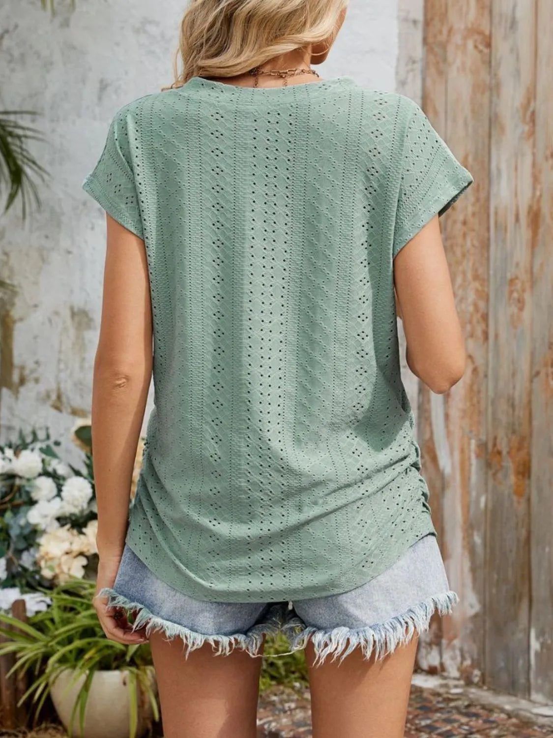 Eyelet V-neck short sleeve top with pockets.