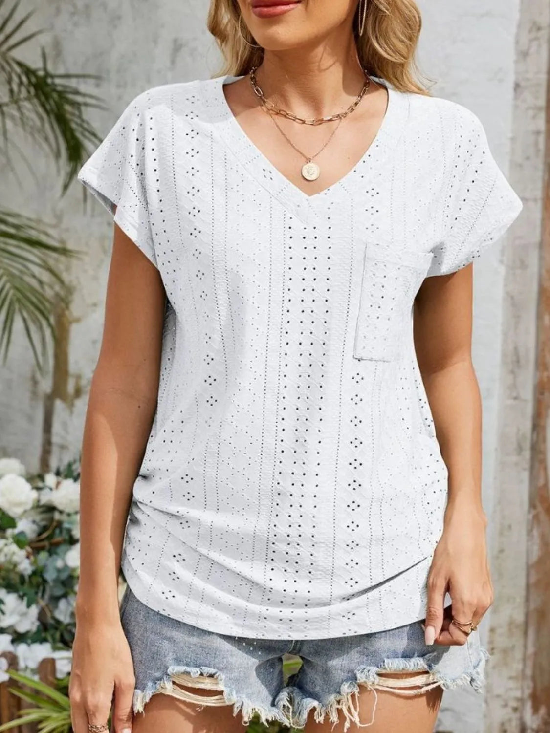 Eyelet V-neck short sleeve top with pockets.