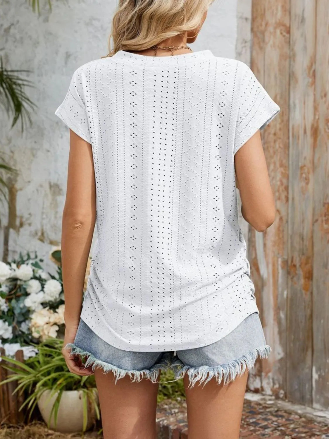 Eyelet V-neck short sleeve top with pockets.