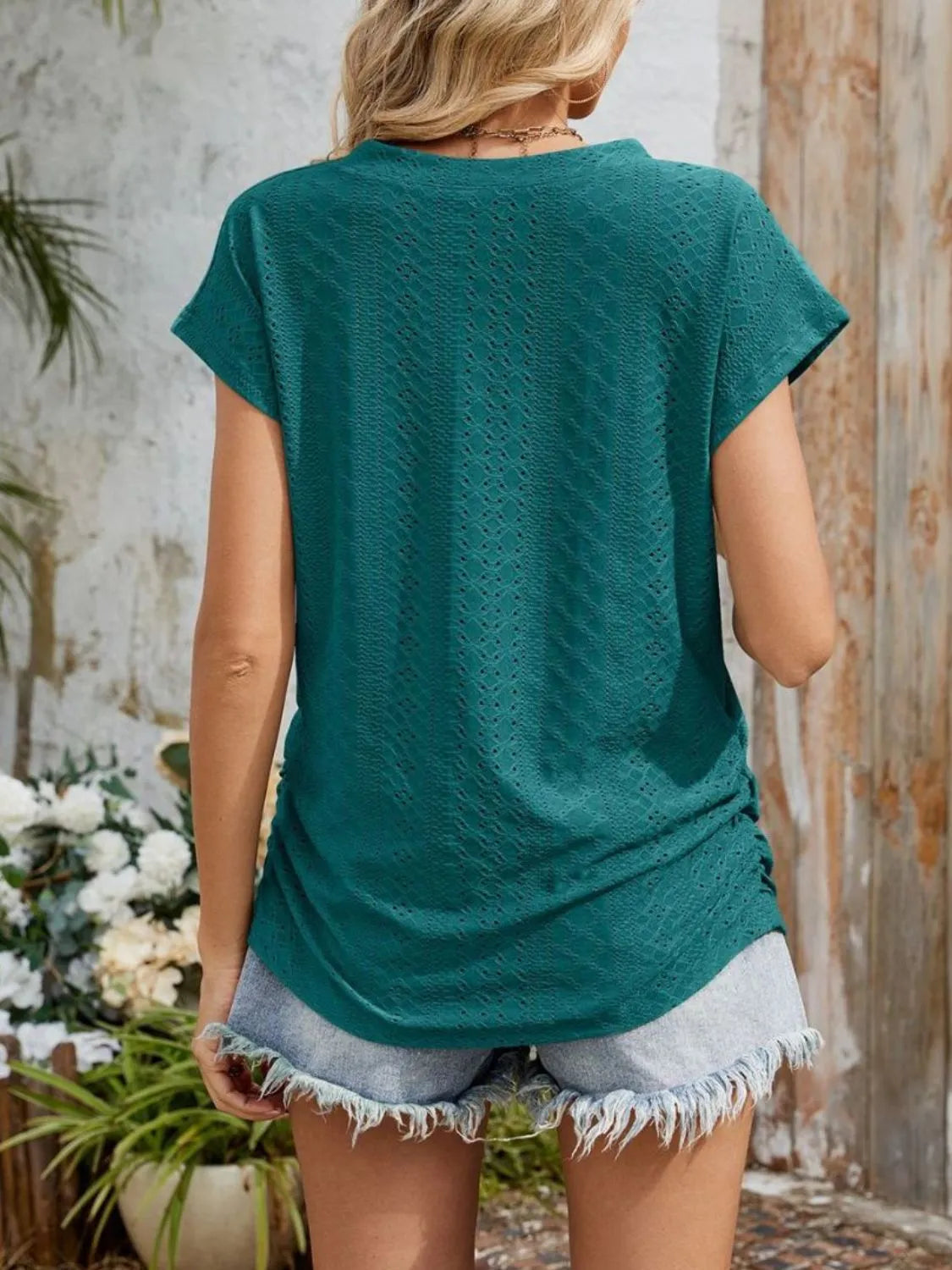 Eyelet V-neck short sleeve top with pockets.