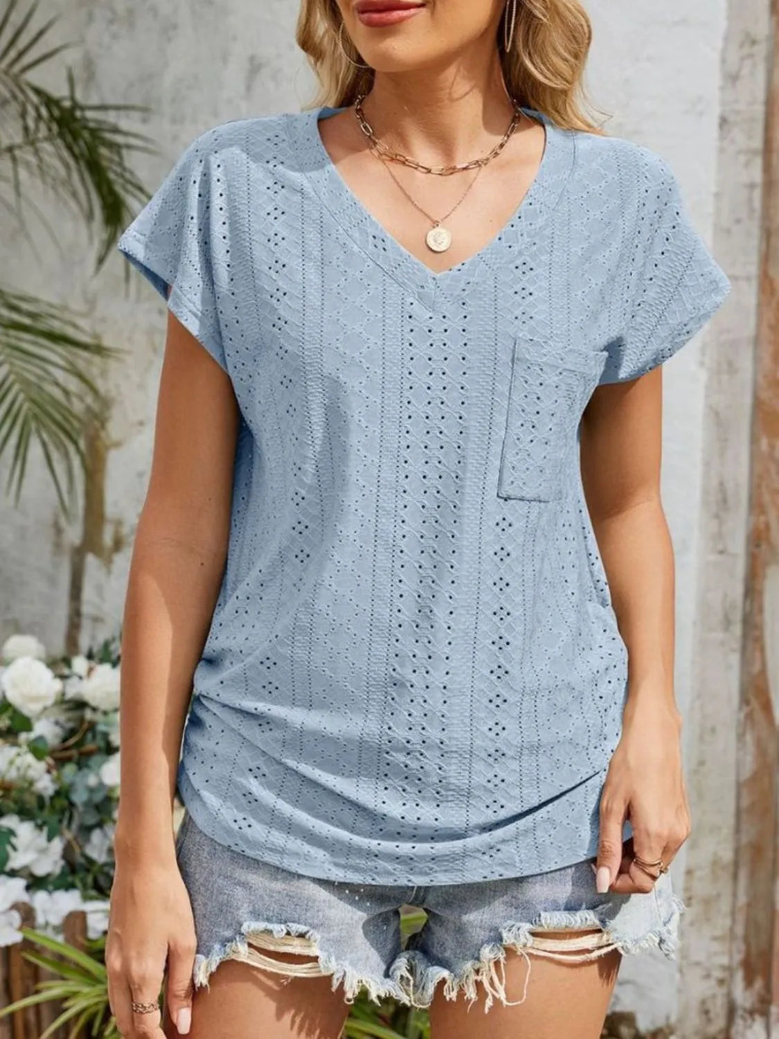Eyelet V-neck short sleeve top with pockets.
