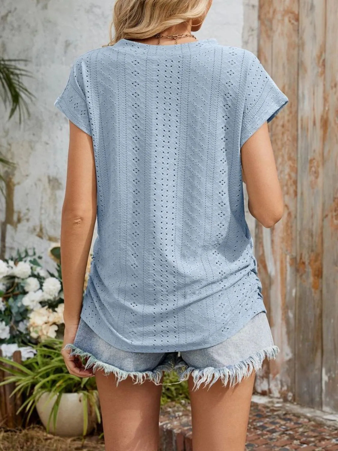 Eyelet V-neck short sleeve top with pockets.