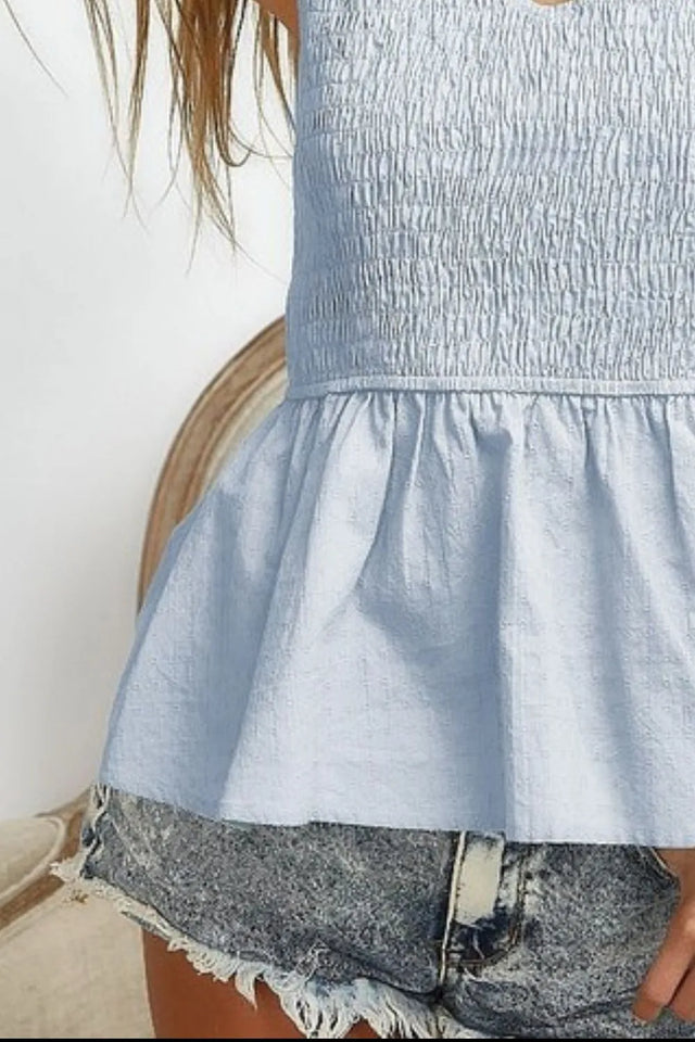 Eyelet woven sleeveless elasticized top with peplum and smocked details.