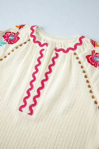 Floral embroidered notched puff sleeve blouse.