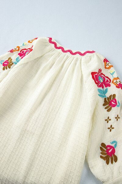 Floral embroidered notched puff sleeve blouse.
