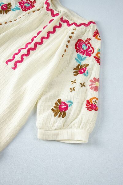 Floral embroidered notched puff sleeve blouse.
