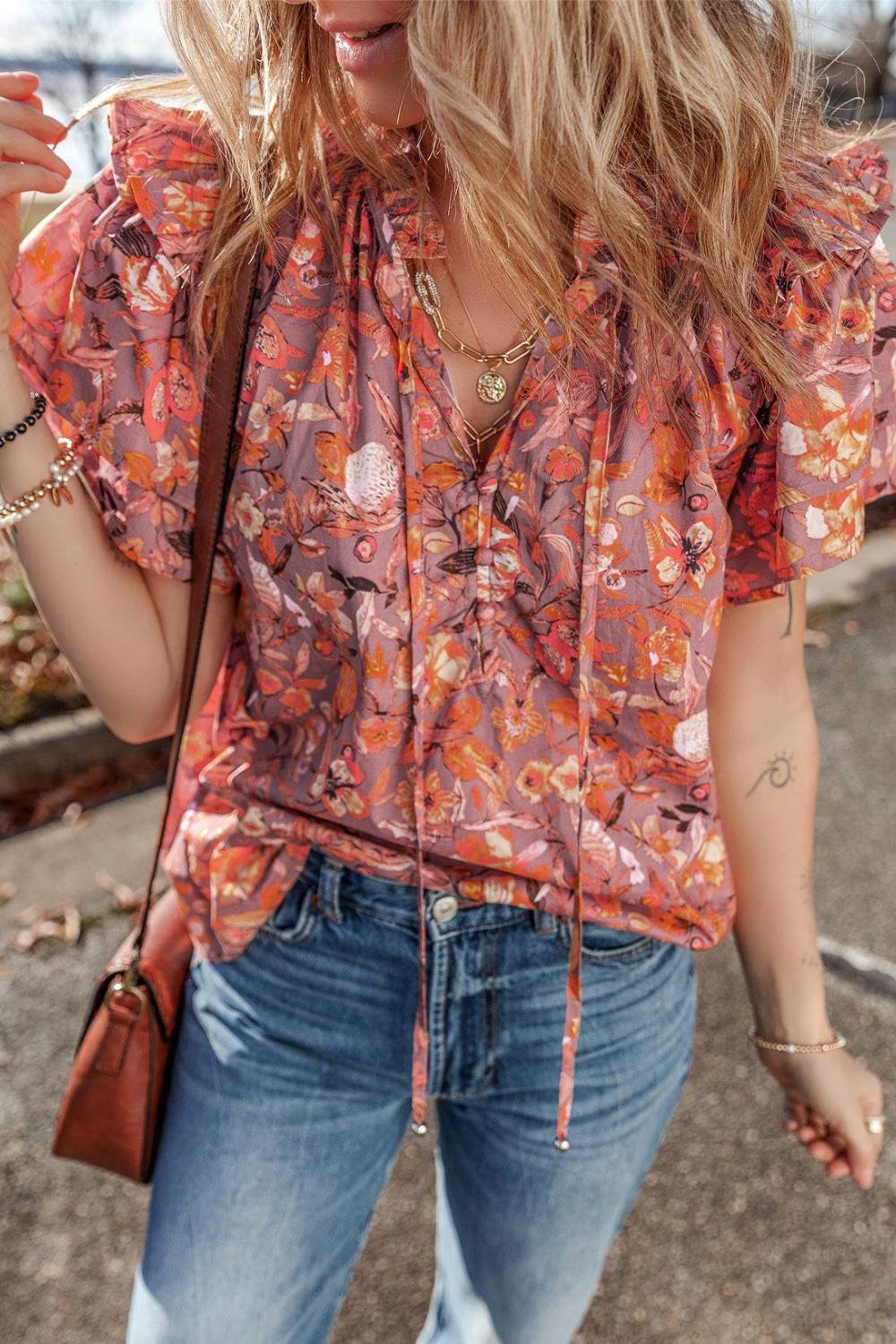 Floral ruffled layered short sleeve tie neck blouse with frill.