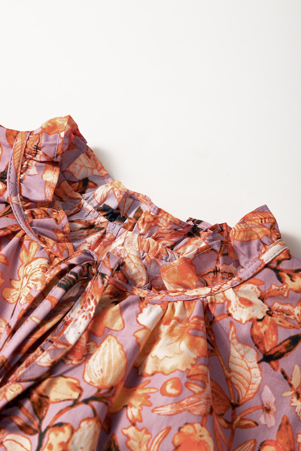 Floral ruffled layered short sleeve tie neck blouse with frill.