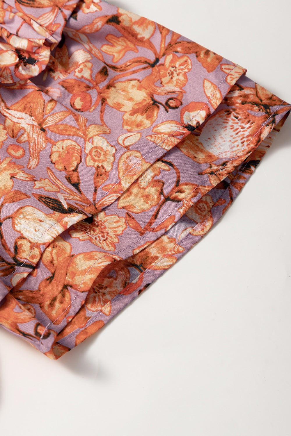 Floral ruffled layered short sleeve tie neck blouse with frill.