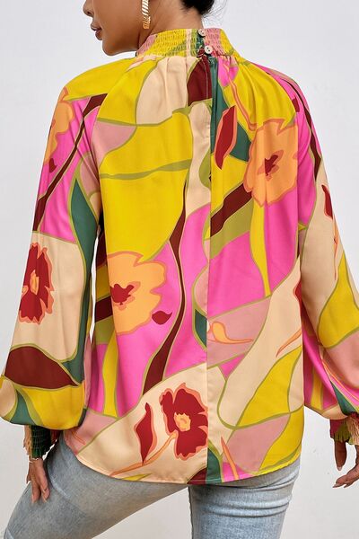 Floral smocked lantern sleeve mock neck blouse.