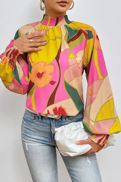 Floral smocked lantern sleeve mock neck blouse.